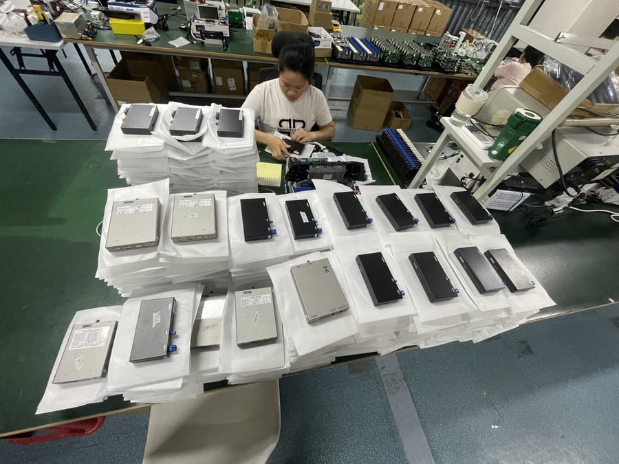工人在流水线上组装无线 CarPlay 解码模块