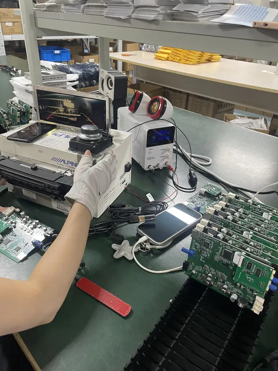 CarPlay decoder module under bench test with a head unit, power supply and boards on the bench