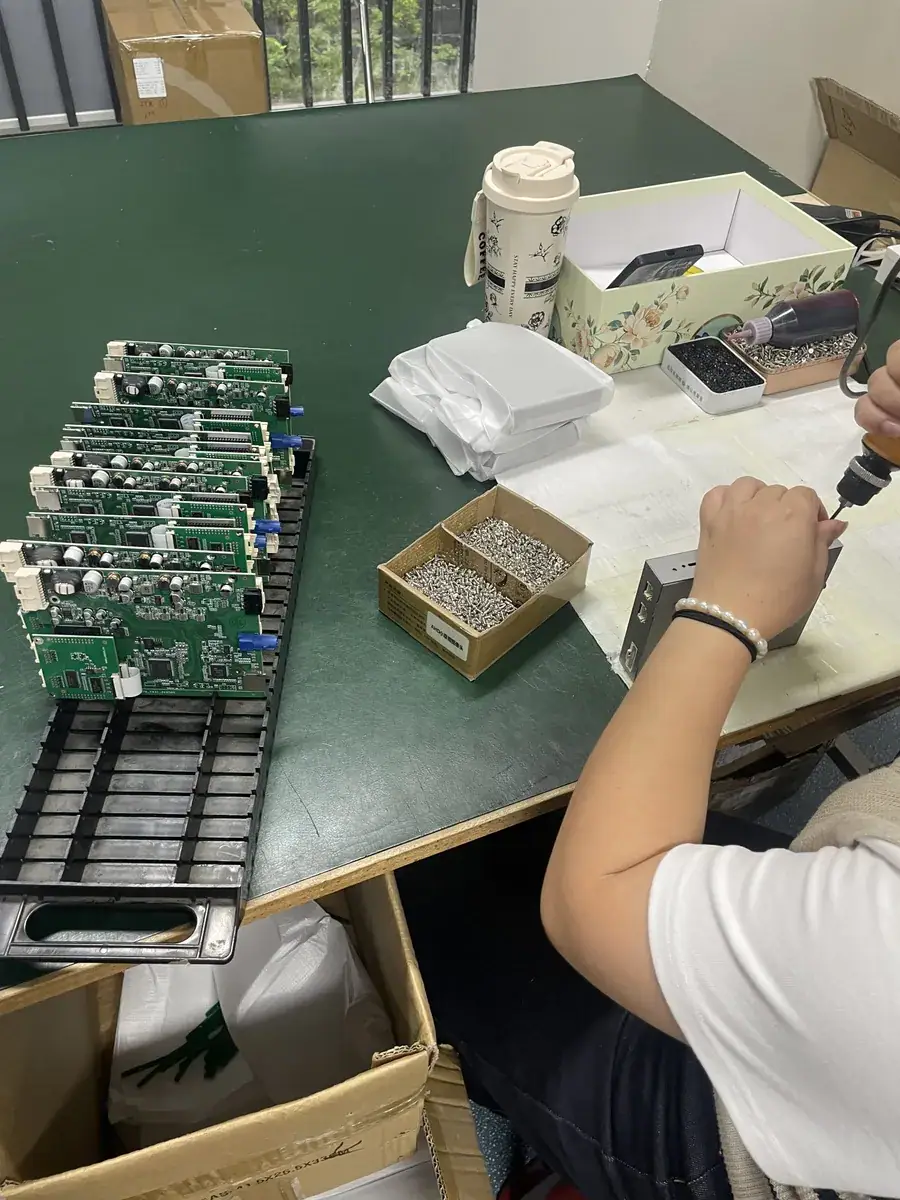 Worker assembling the PCB of a CarPlay decoder module in the factory