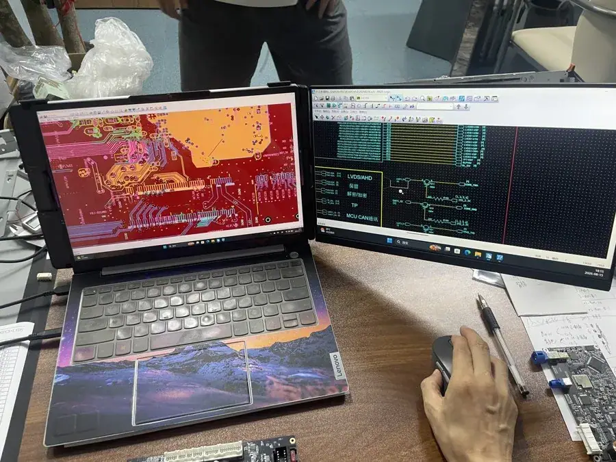 CarPlay decoder module PCB layout and schematic under R&D review on a dual-screen engineering bench