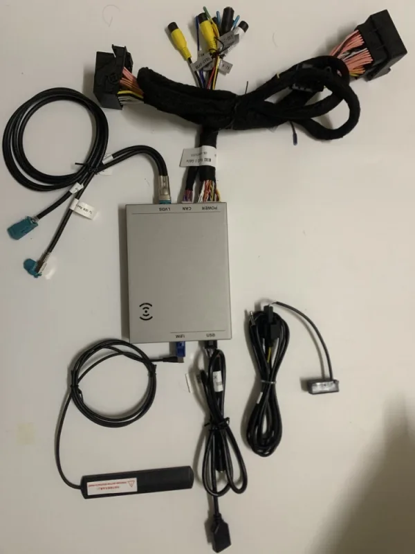 CarPlay decoder module harness with WiFi antennas and LVDS leads laid out on the bench before fitting